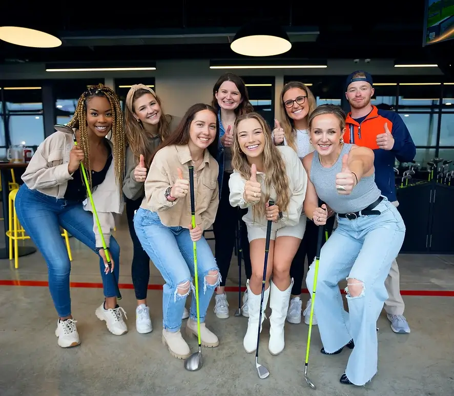 Women smiling and gesturing the okay sign, expressing their love for golf.